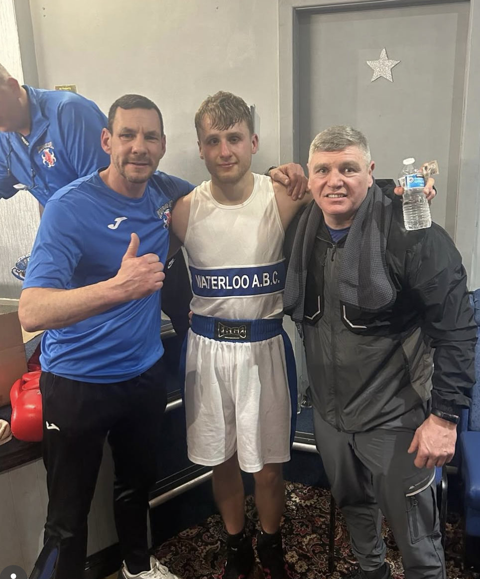Teen boxer with coaches after a successful bout
